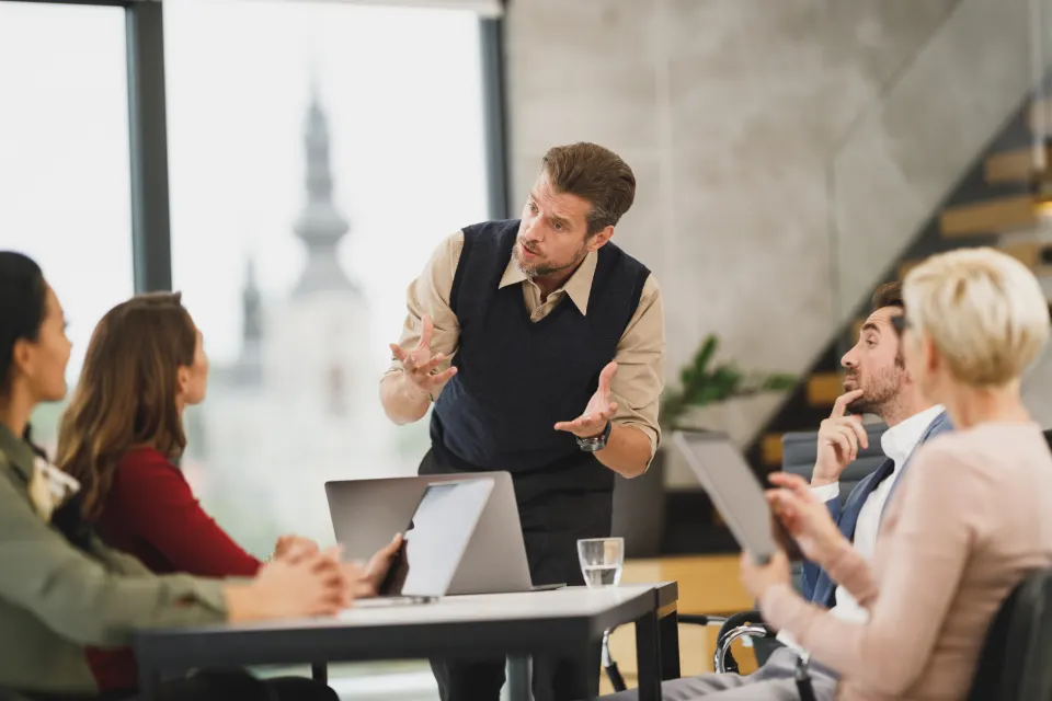 A manager leading a team training session around a meeting table