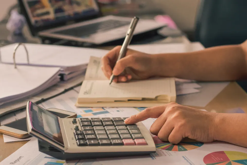Working through figures with a calculator and paperwork