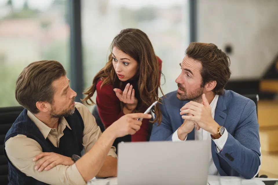 Colleagues in a tense discussion at a laptop