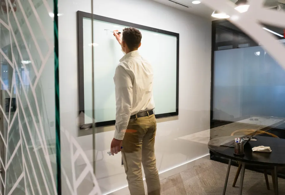 A man at a screen in a meeting room