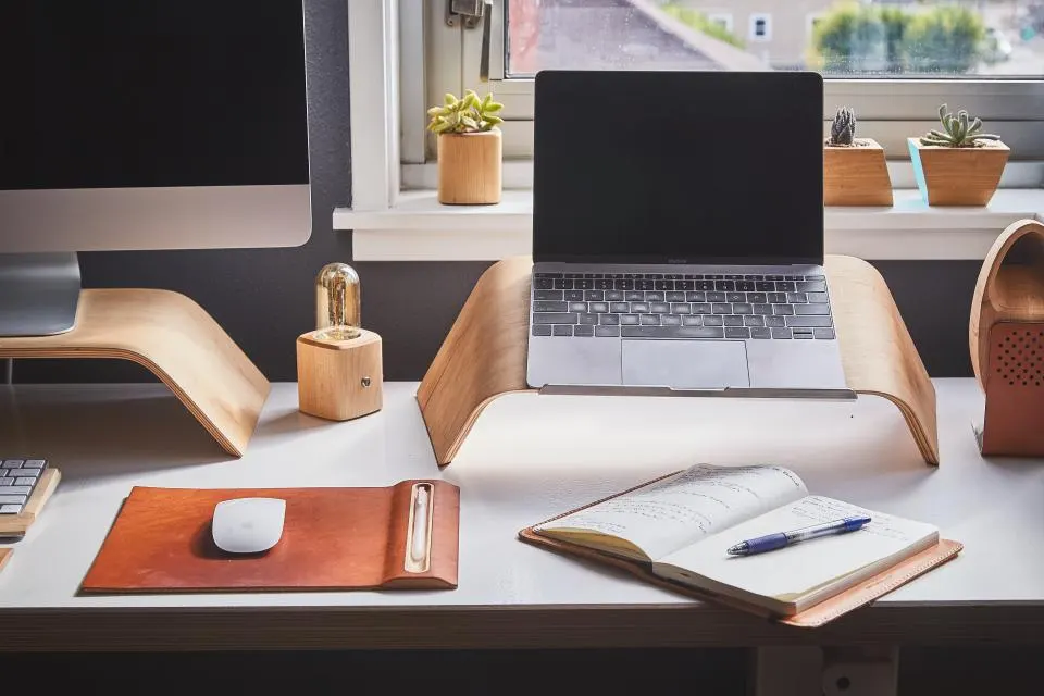 An empty desk with a laptop and a notebook