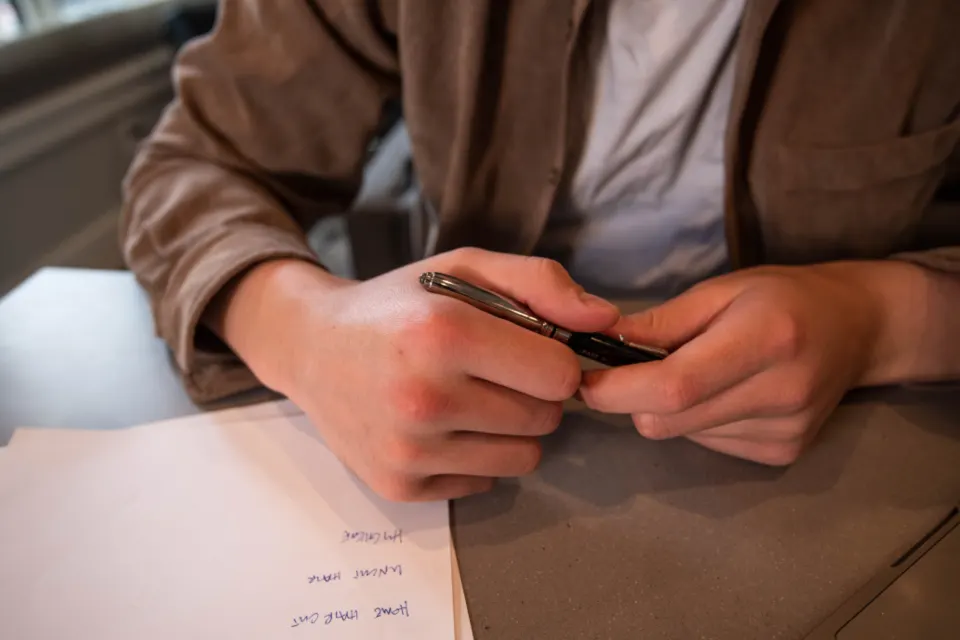 A person reading through a document with a pen in hand