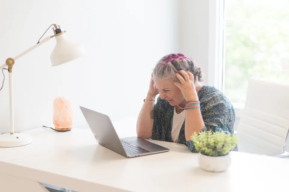 A person at a desk with their head in their hands